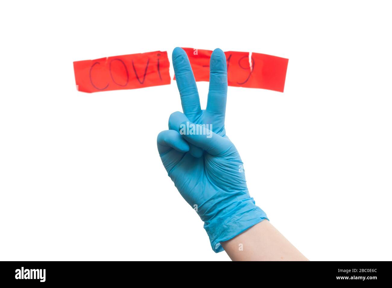 Medics defeated coronavirus. Concept. Hand in a medical glove with a red label of coronavirus Stock Photo