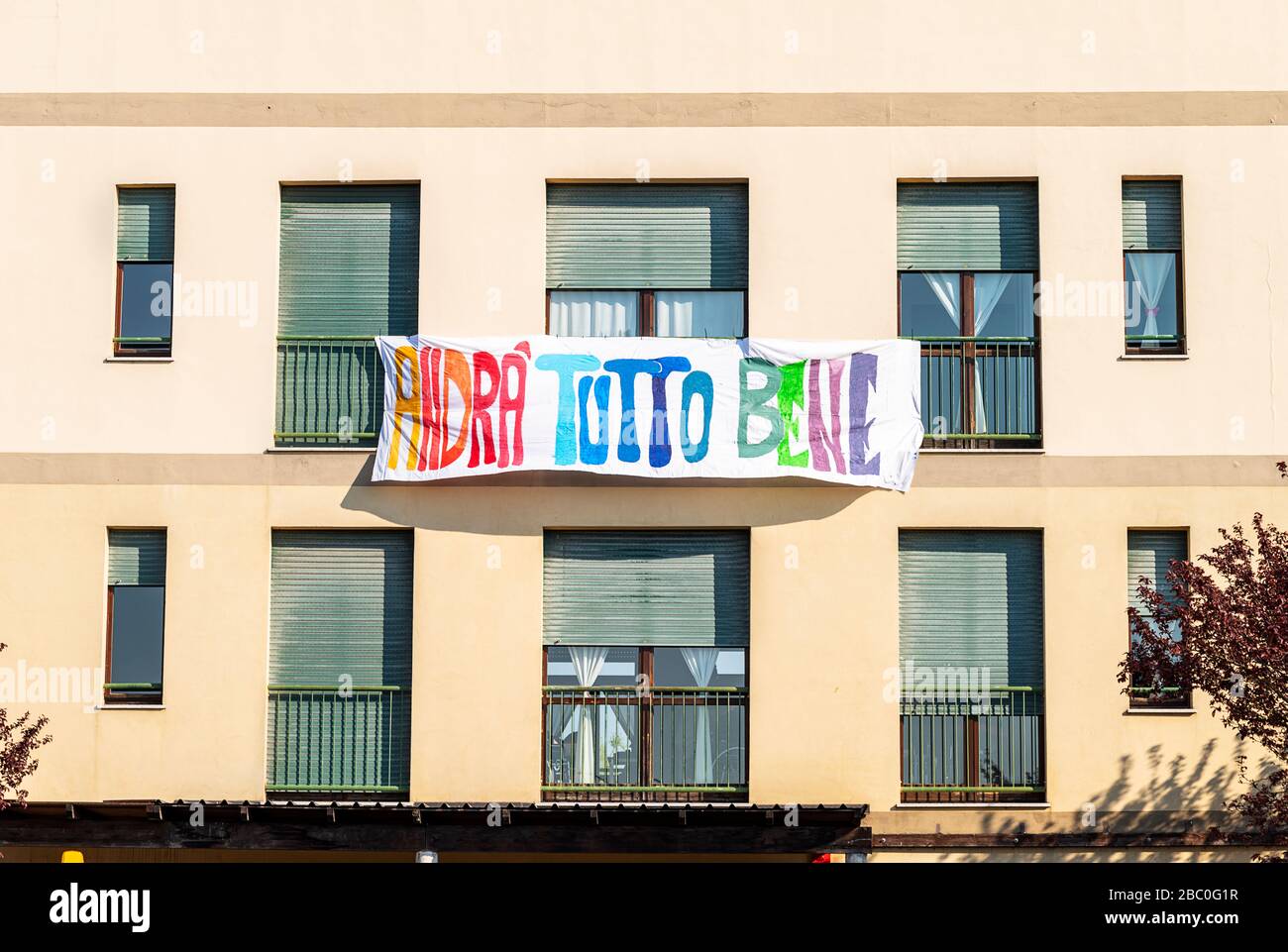 Facade of an house with a banner ‘andrà tutto bene’, italian message of hope in coronavirus times Stock Photo