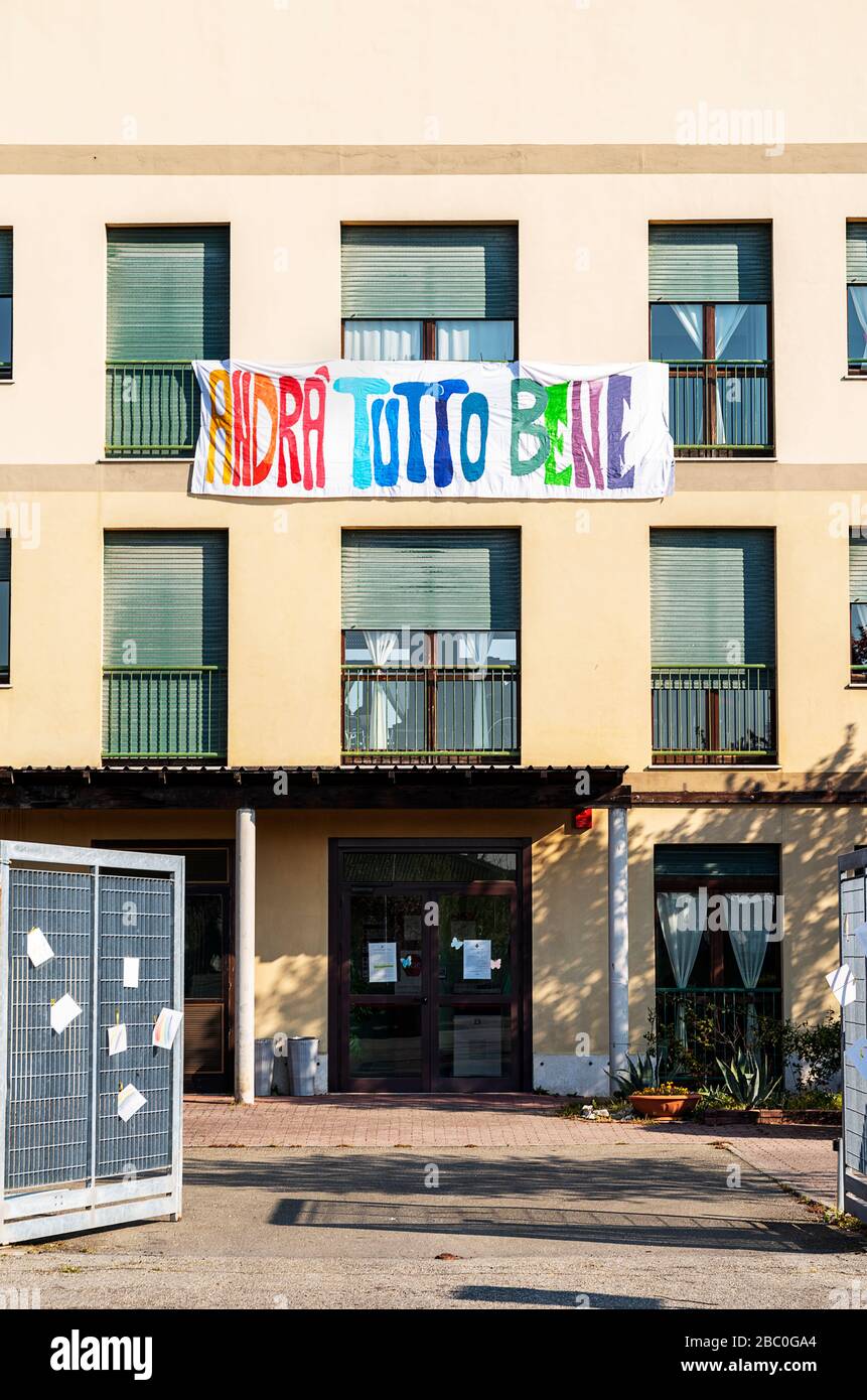 Facade of an house with a banner ‘andrà tutto bene’, italian message of hope in coronavirus times Stock Photo