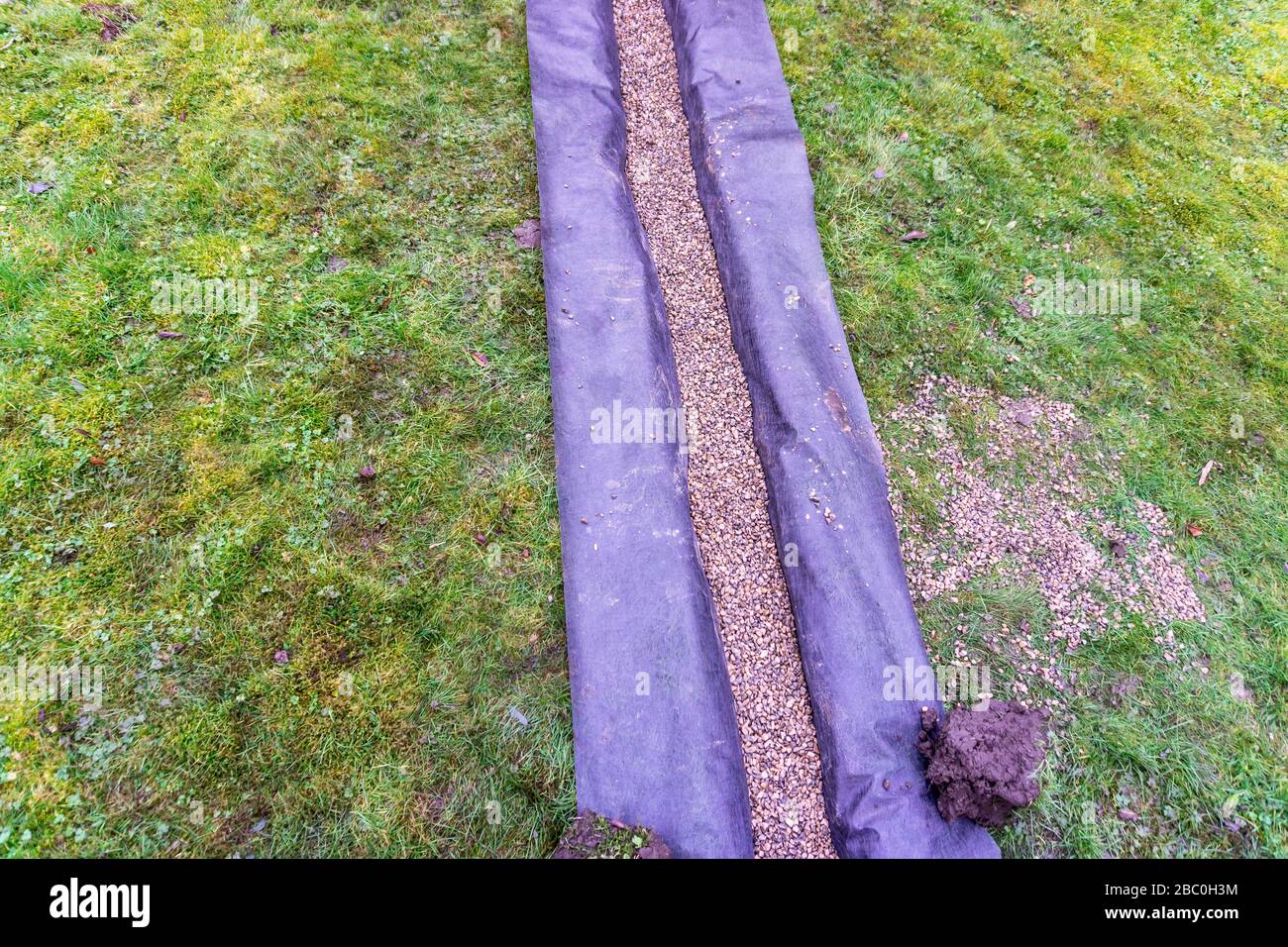 Installing a drainage trench in a garden lawn, Stock Photo