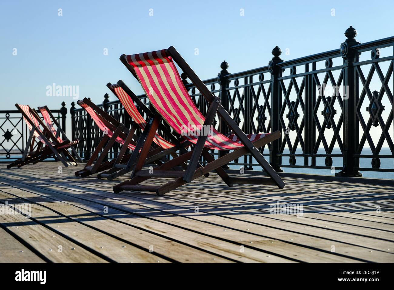 Deck chairs for visitors to relax and enjoy the view on Hastings Pier, East Sussex, UK Stock Photo
