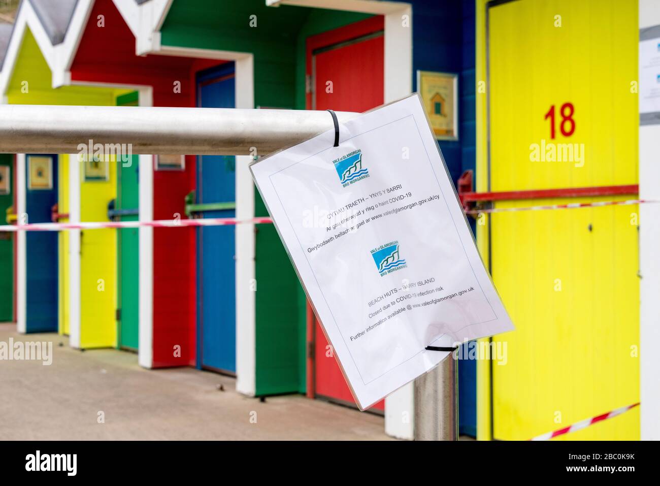 Beach huts at Barry Island are taped off and a council notice prohibits access during the Covid-19 crises. Stock Photo