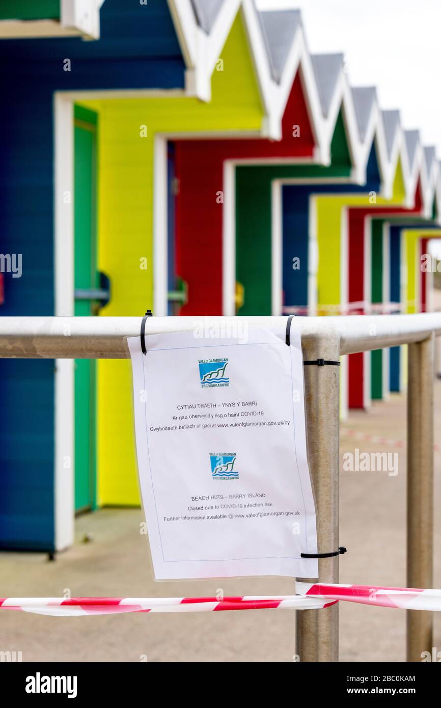 Beach huts at Barry Island are taped off and a council notice prohibits access during the Covid-19 crises. Stock Photo
