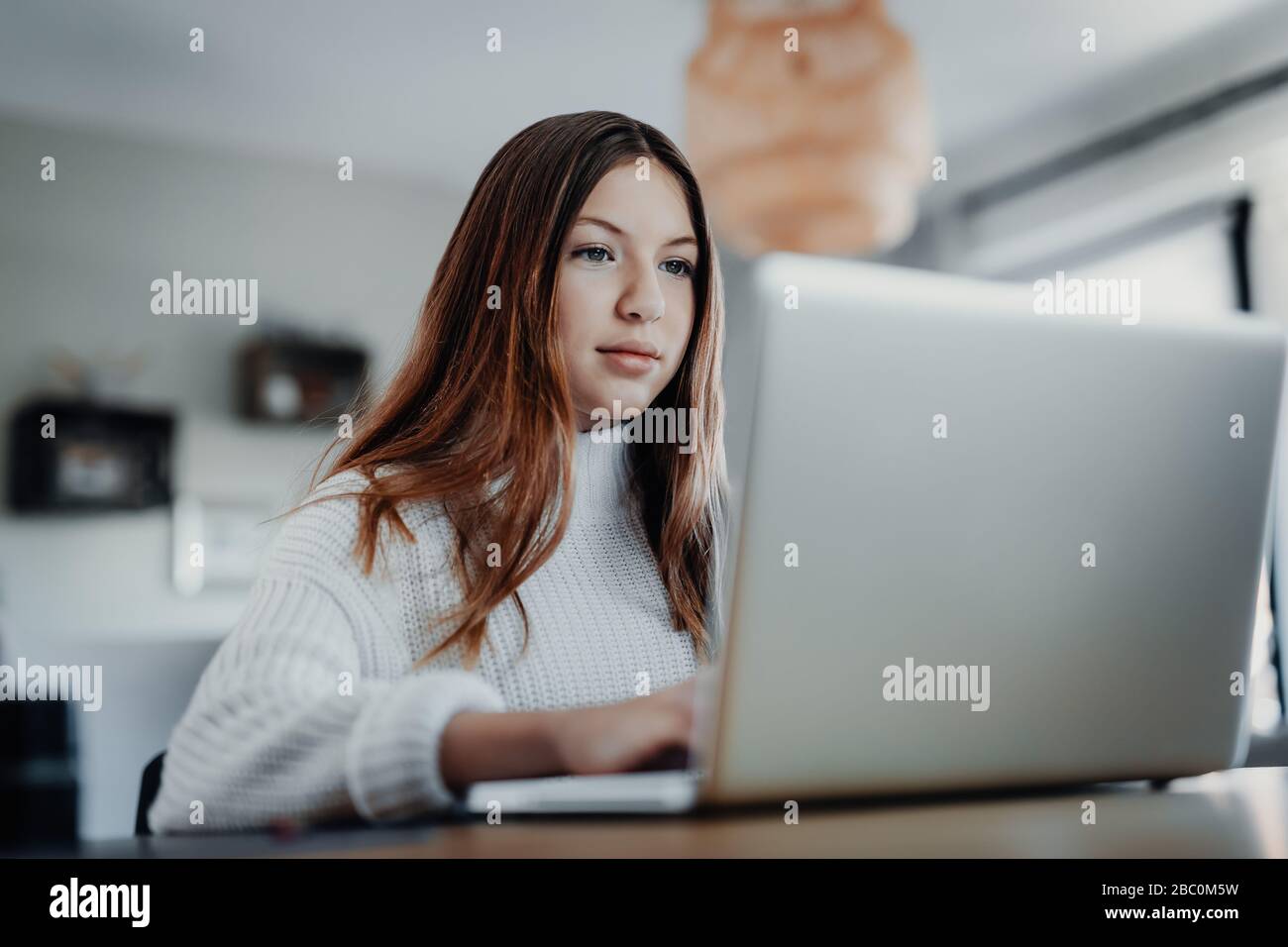 Child doing homeschooling, e-learning at home because of the corona virus pandemic covid-19 quarantine Stock Photo