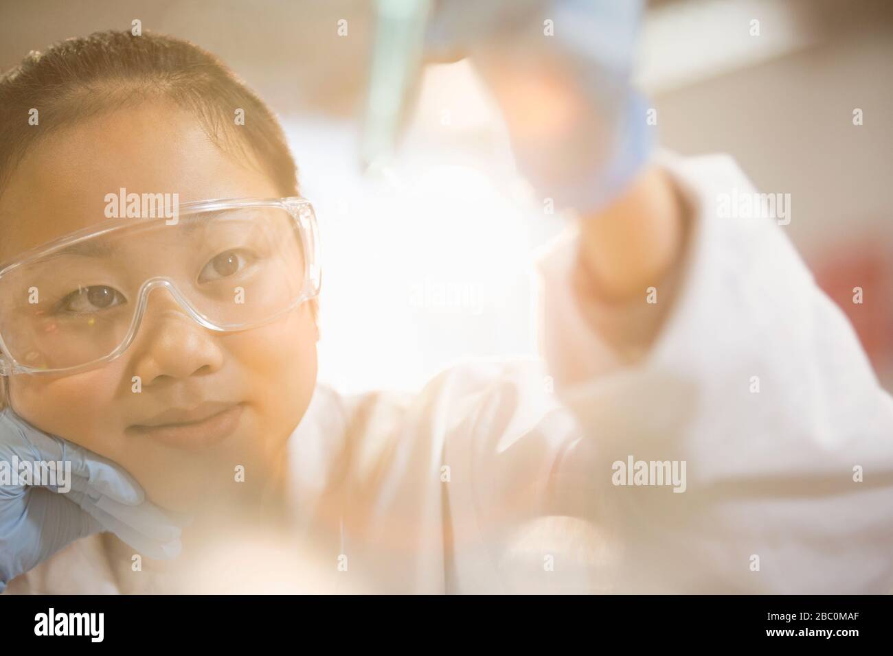 Pensive girl student conducting science experiment in classroom laboratory Stock Photo