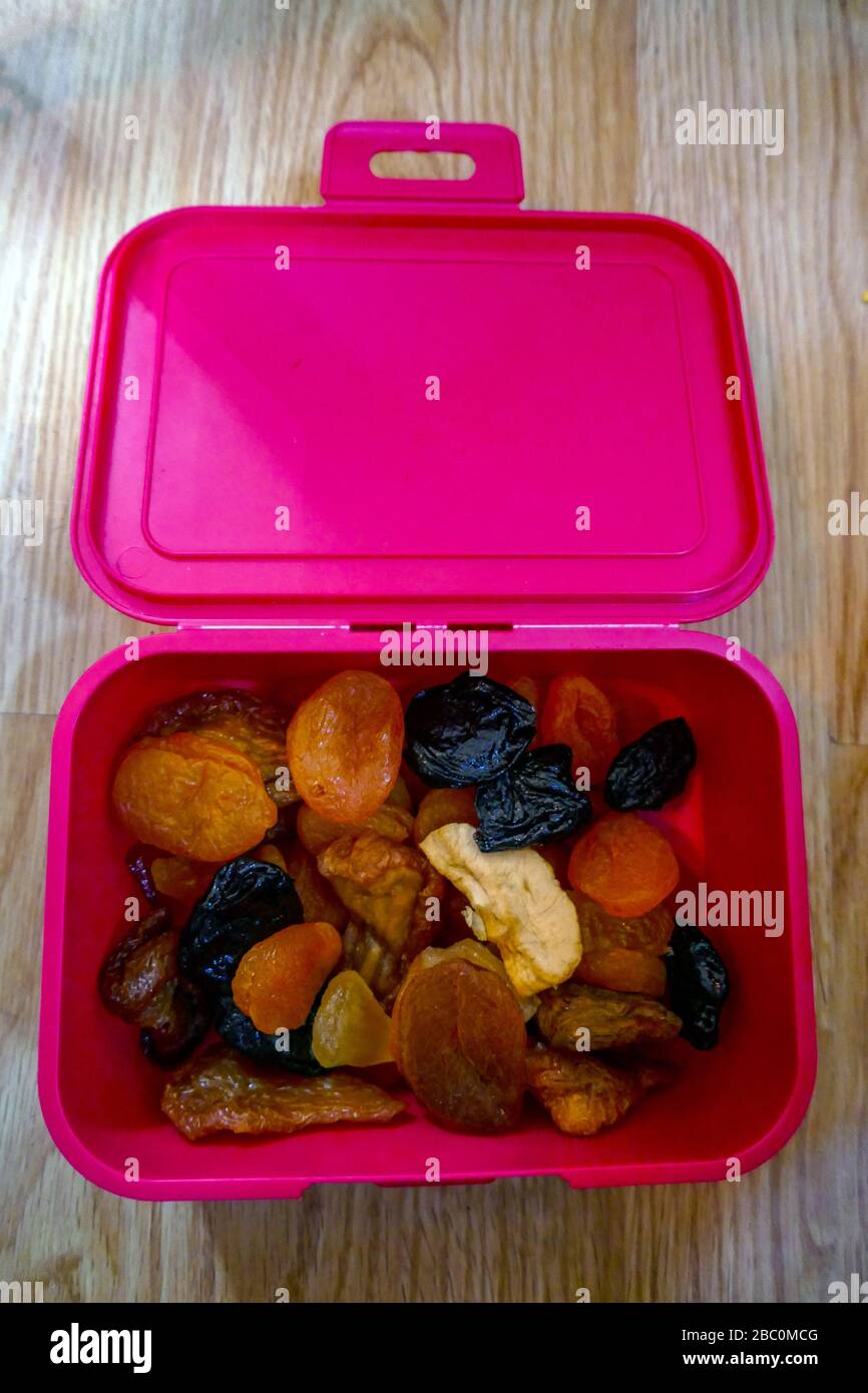 Various dried fruit in pink plastic box, Ornolac, Ussat les Bains, Ariege, French Pyrenees, France Stock Photo