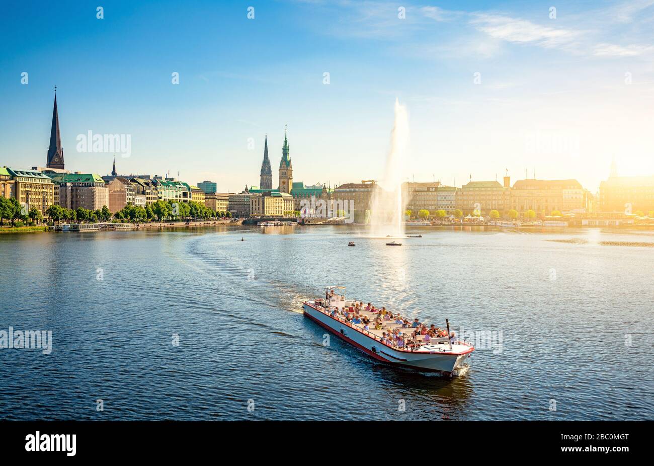 Classic panoramic view of famous Binnenalster (Inner Alster Lake) with fountain, tourist boat and the historic Hanseatic City of Hamburg Stock Photo