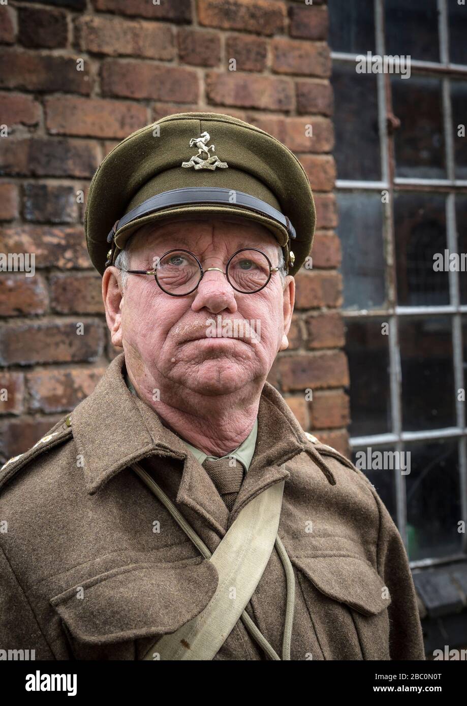 Close-up portrait of man in Home Guard army uniform as Captain Mainwaring isolated outdoors, Black Country Living Museum 1940s wartime summer event UK. Stock Photo