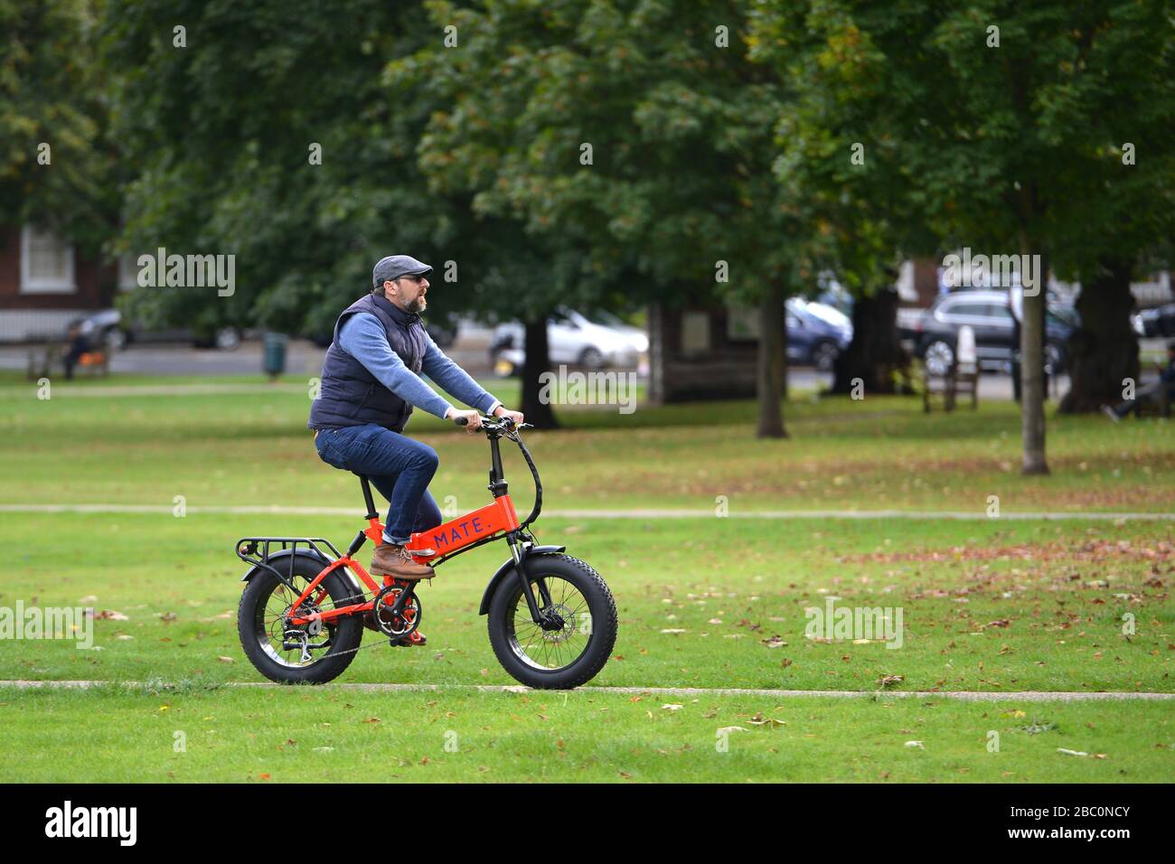 Man cycling on Richmond Green, Richmond, London, UK Stock Photo
