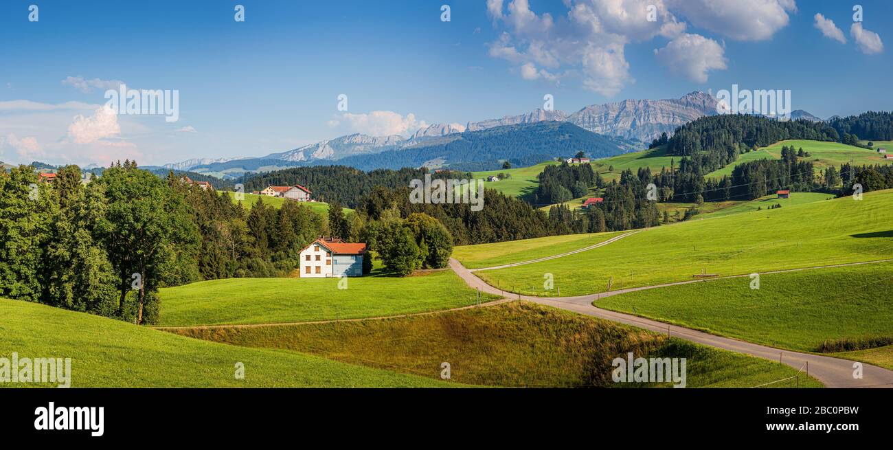 Beautiful view of idyllic Swiss mountain scenery in the Alps with green meadows and famous Saentis summit in the background in summer, Switzerland Stock Photo