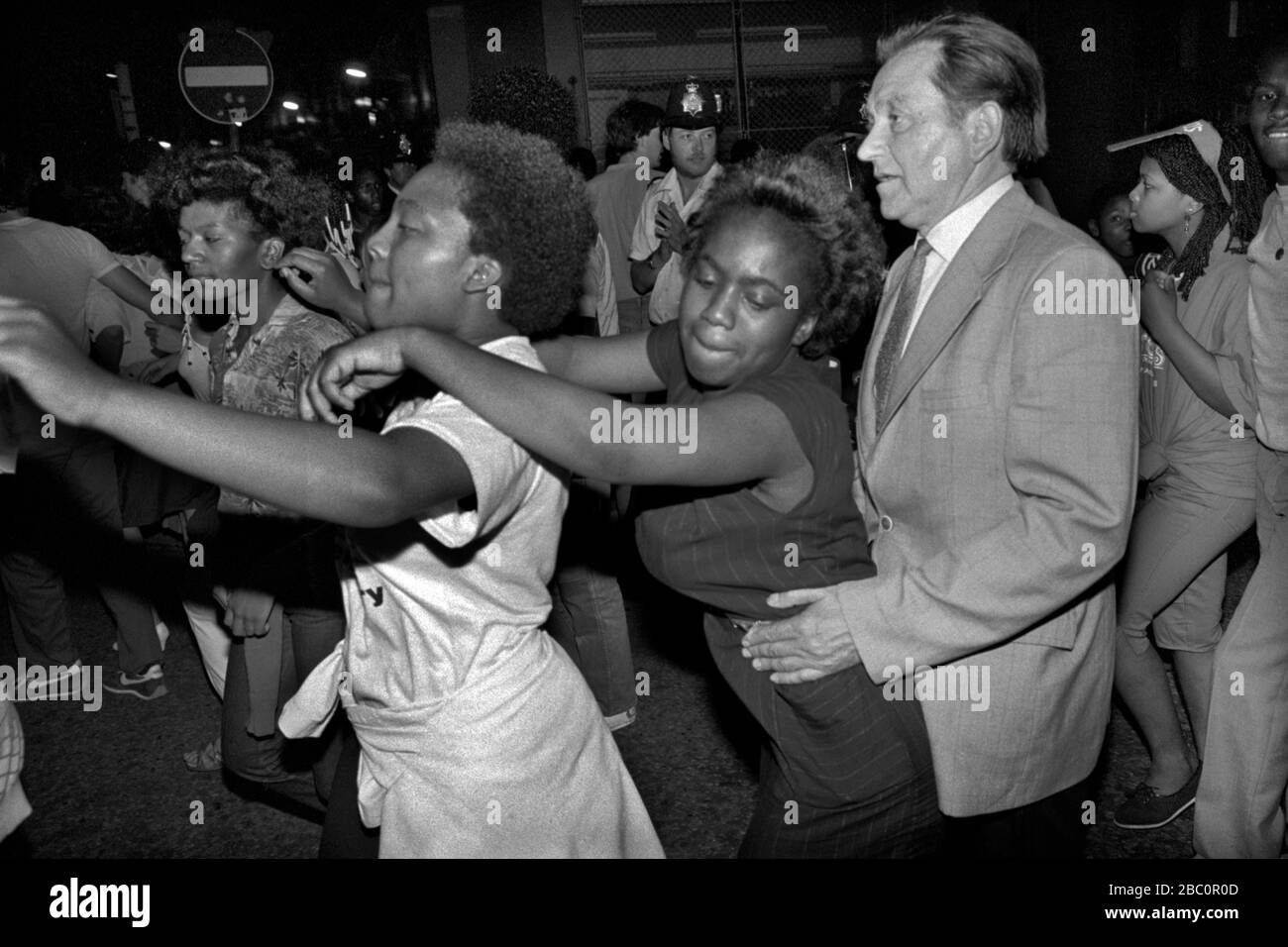 Conga Line dancing Notting Hill Carnival London 1981. Older white male too close to black female taking part in the black community Conga Line Dance. 1980s UK HOMER SYKES Stock Photo