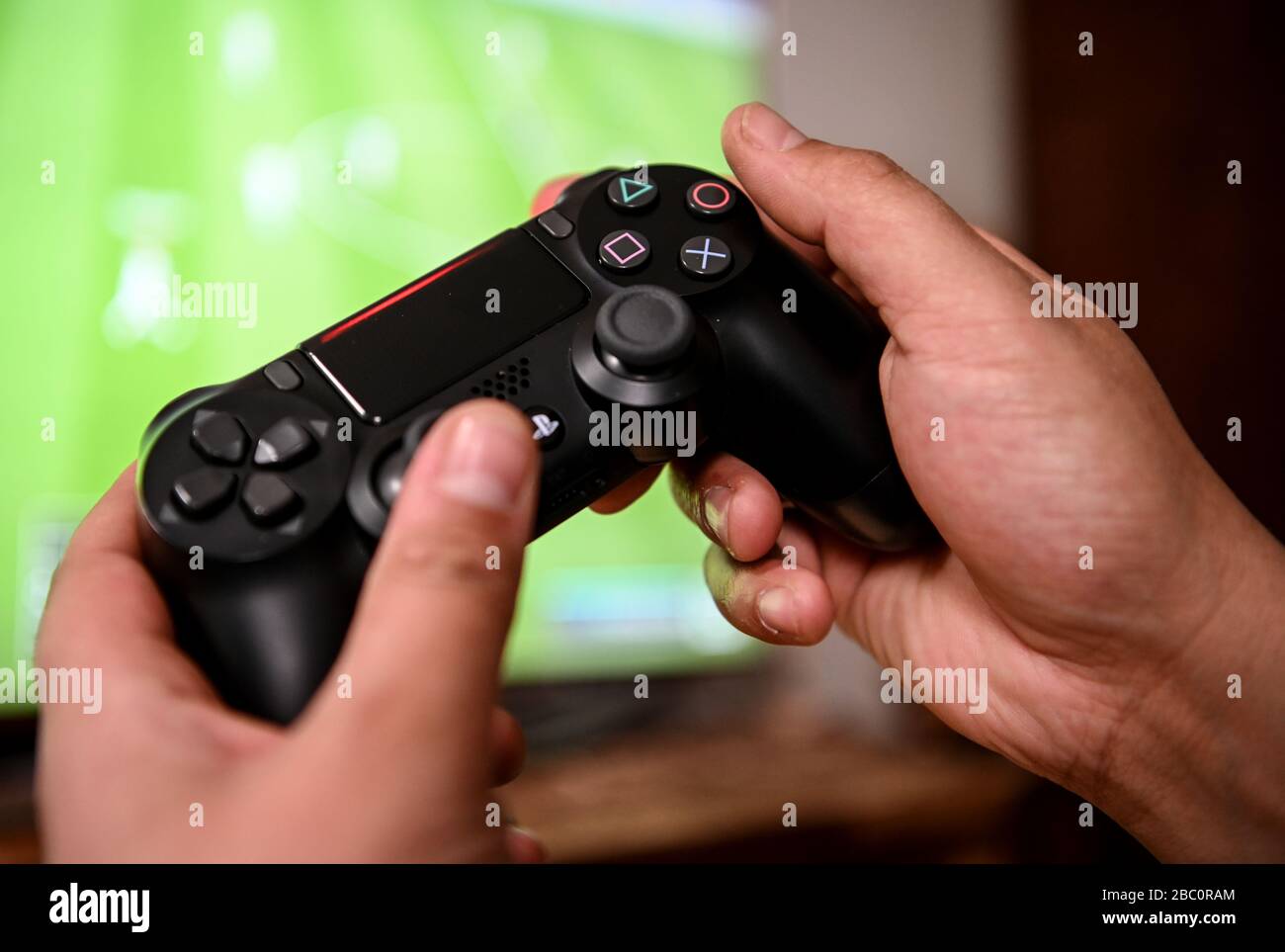 Berlin, Germany. 02nd Apr, 2020. A young man plays with the game console Playstation  4. to prevent infection with the corona virus, many people spend their free  time at home. Credit: Britta
