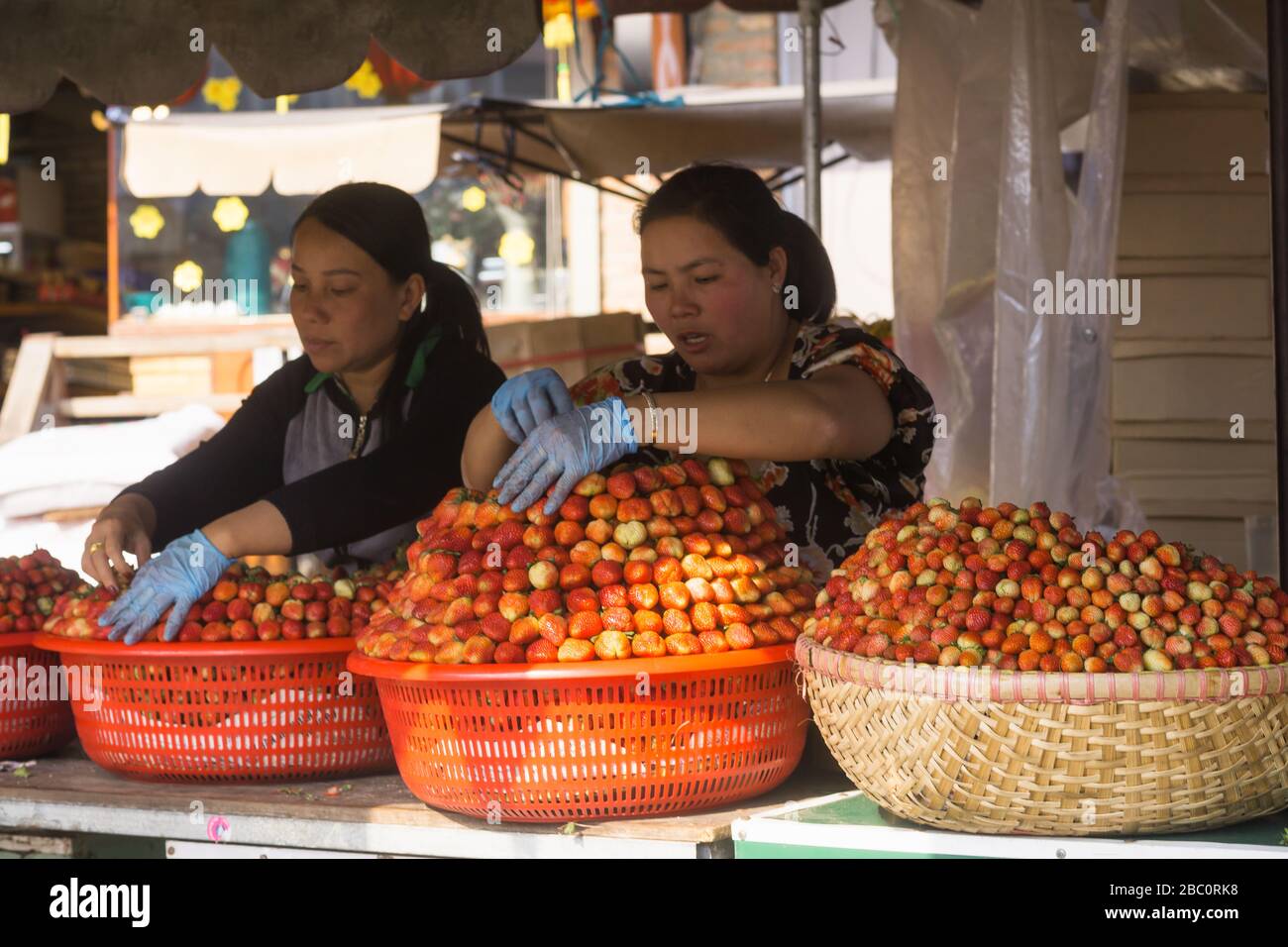 Dalat market - Women vendors selling strawberries at the main market in Dalat, Vietnam, Southeast Asia. Stock Photo