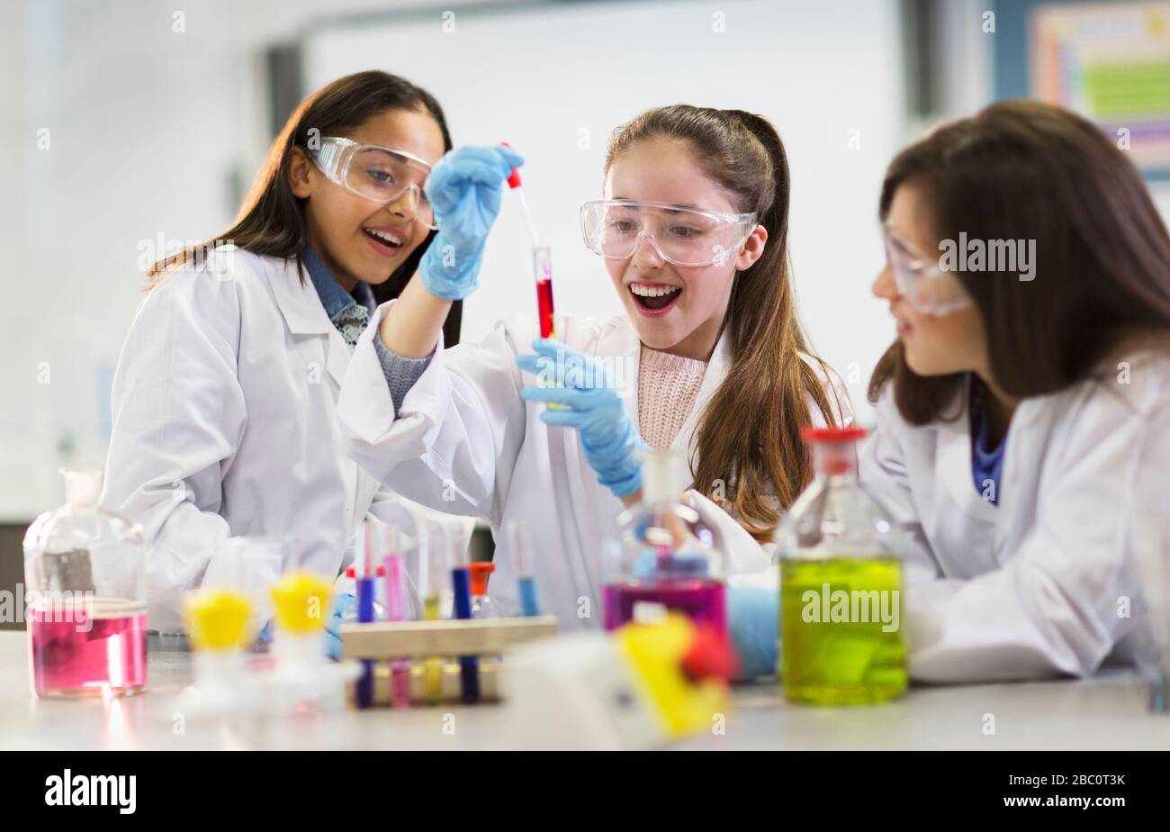 Curious girl students conducting scientific experiment in laboratory classroom Stock Photo
