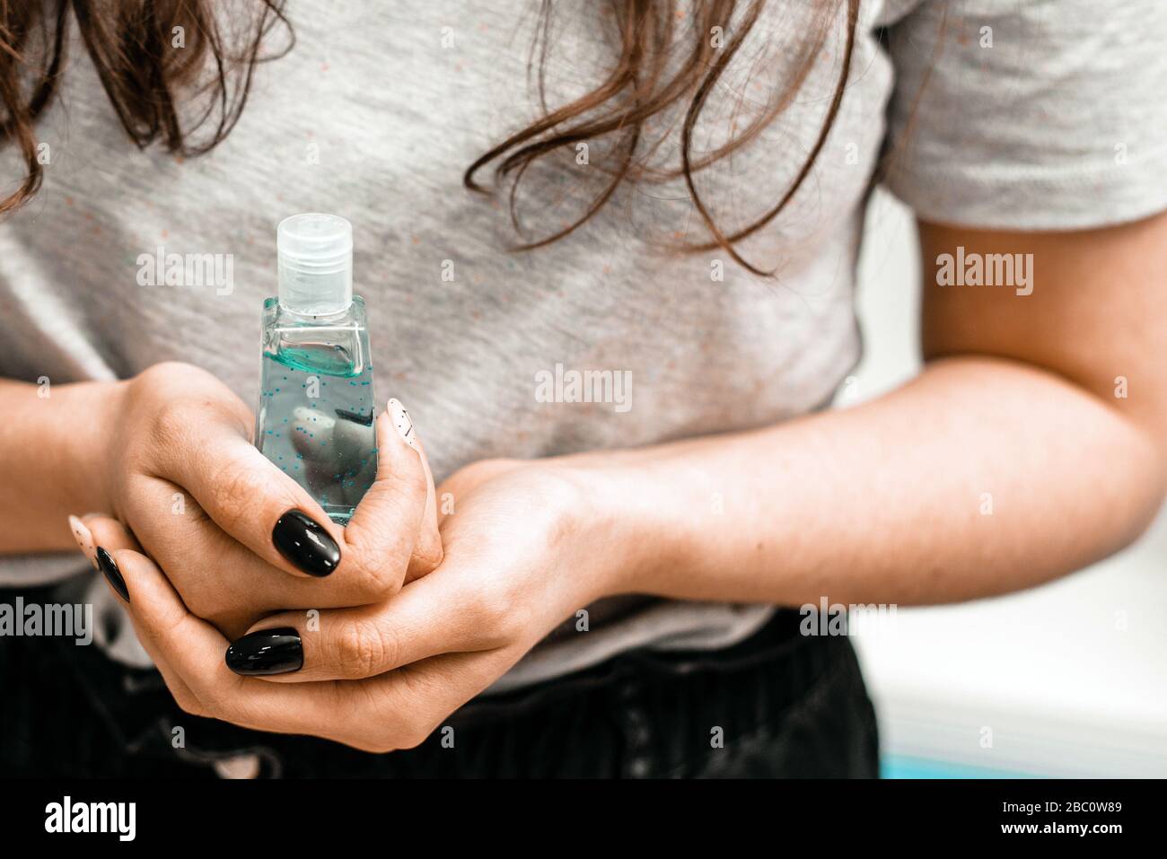 Girl holds antibacterial gel sanitizer in her hands. Prevention and precautions in the fight against coronavirus. Stock Photo