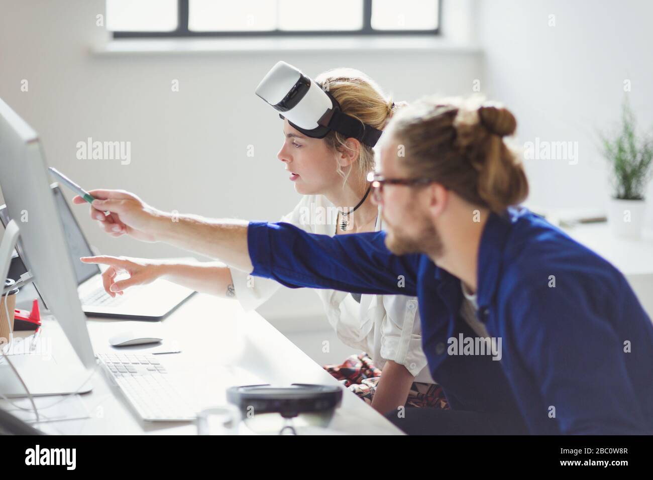 Computer programmers programming virtual reality simulator glasses in office Stock Photo