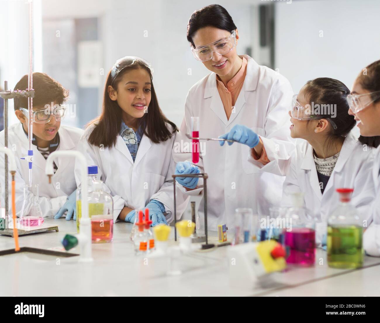 Female teacher and students conducting scientific experiment in laboratory classroom Stock Photo