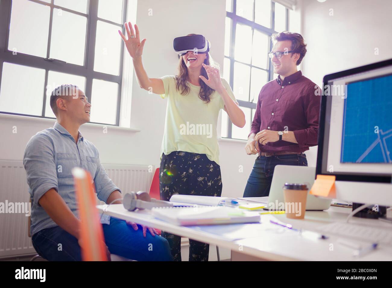 Enthusiastic computer programmers testing virtual reality simulator glasses in office Stock Photo