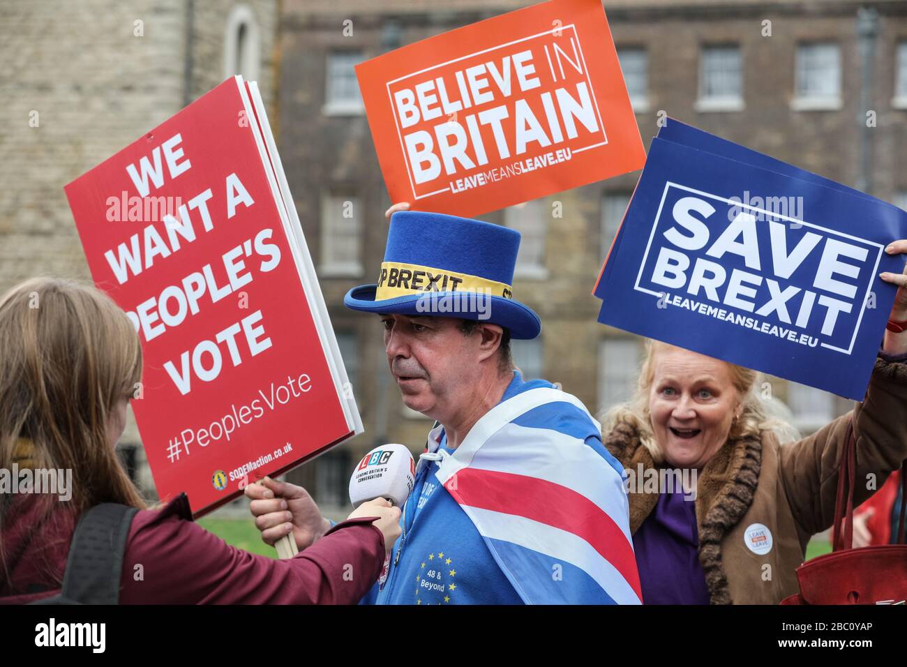Anti-Brexit protester Steven Bray interviewed in Westminster, Pro-Brexit demonstrators in background, London, UK Stock Photo