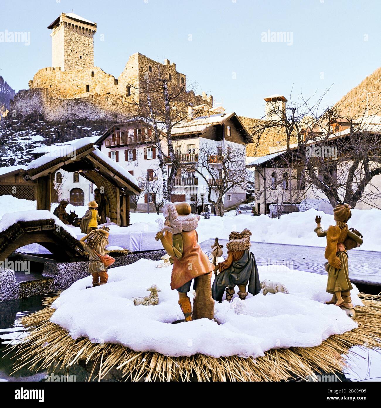 Ossana, Italy - December 26, 2019: Outdoor nativity scene covered in snow. In the background the famous castle of San Michele. Stock Photo