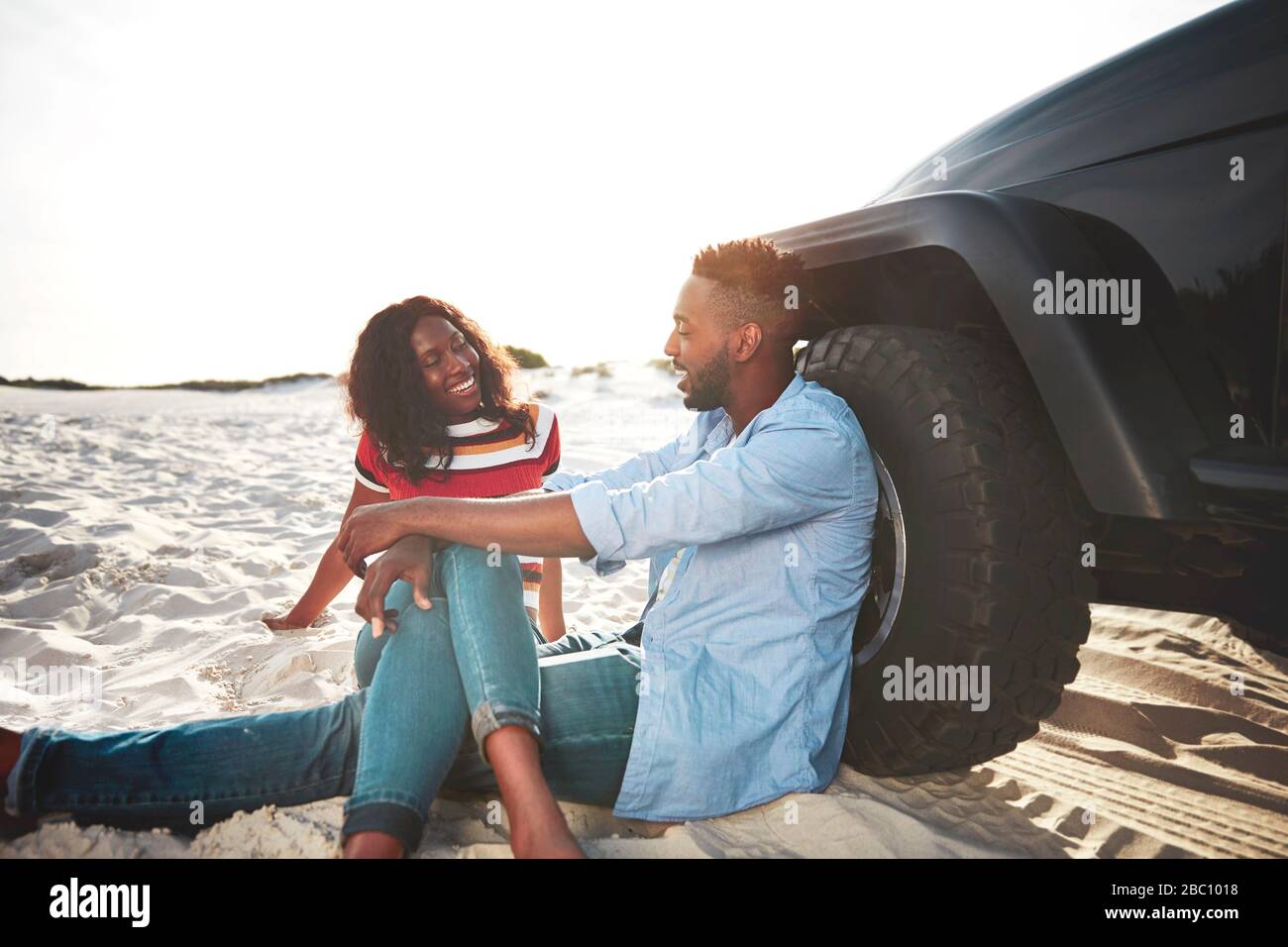 Young couple relaxing, hanging out on beach Stock Photo