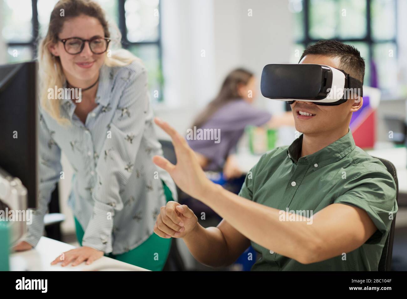 Computer programmers testing virtual reality simulator glasses in office Stock Photo