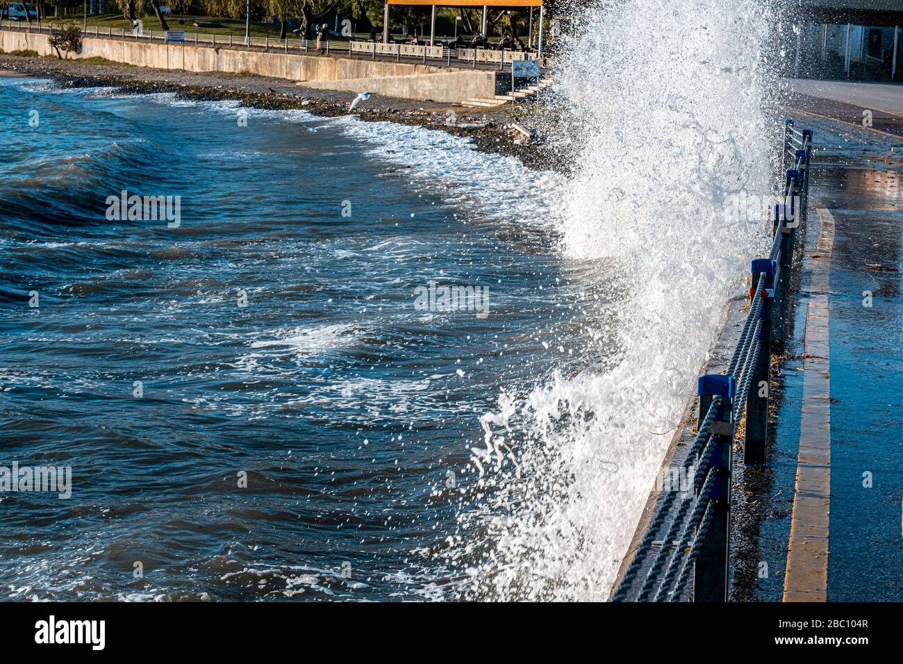 Powerful waves breaking at seawall during a storm in the daytime in ...