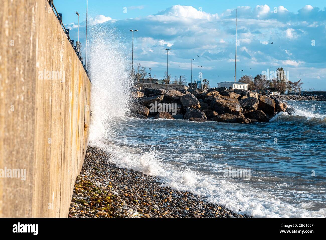 Powerful waves breaking at seawall during a storm in the daytime in ...