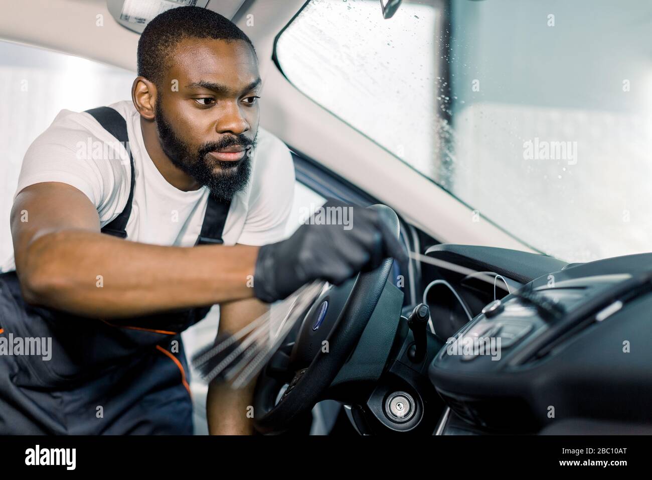 African man, professional car service worker in black protectibe gloves