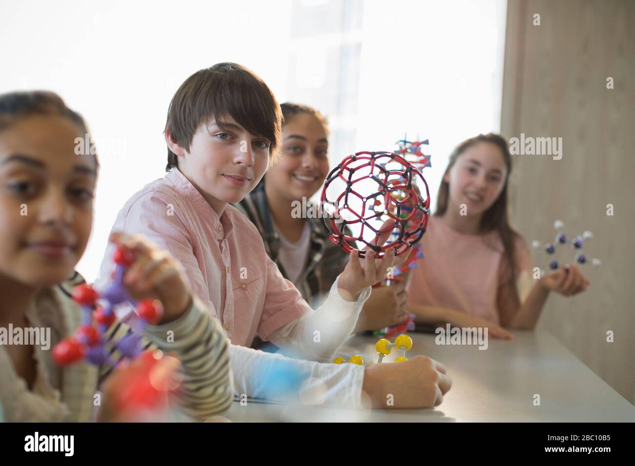 Portrait confident students holding molecular structures in laboratory classroom Stock Photo