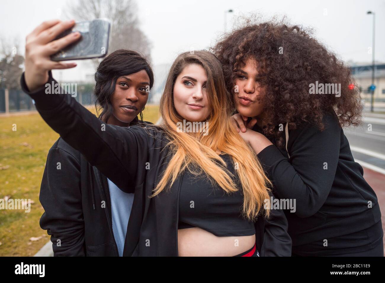 Three sportive young women taking selfie in the city Stock Photo - Alamy