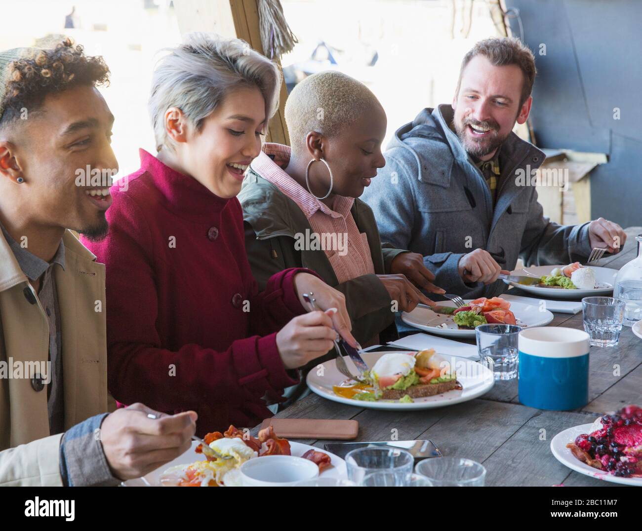 Friends eating breakfast at restaurant outdoor patio Stock Photo