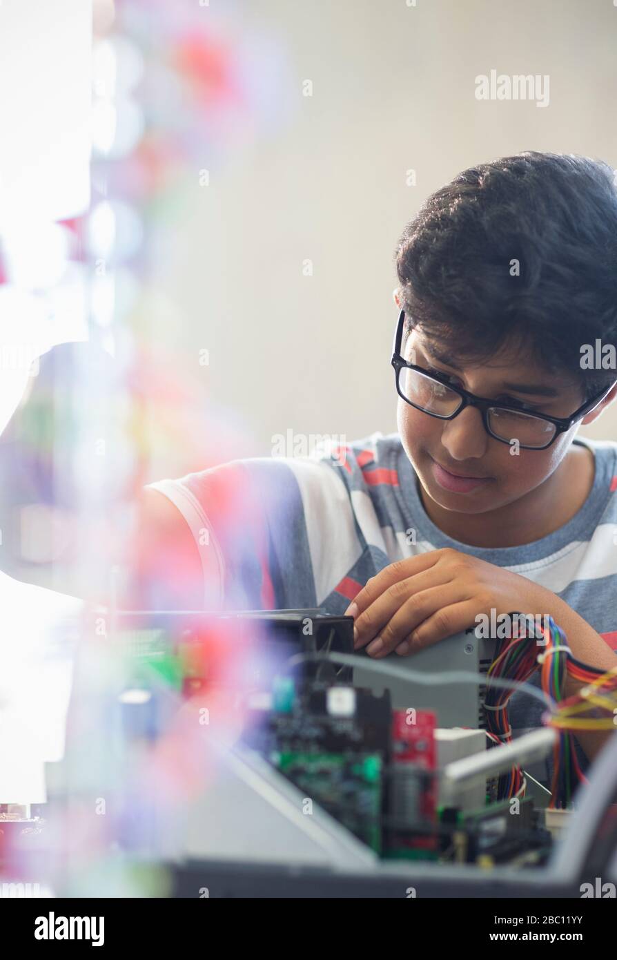Focused boy student assembling computer in classroom Stock Photo