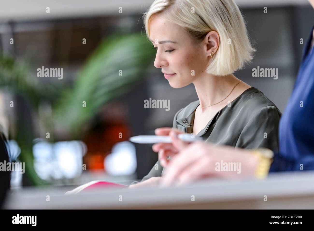 Attentive businesswoman sitting meeting, listening focussed Stock Photo