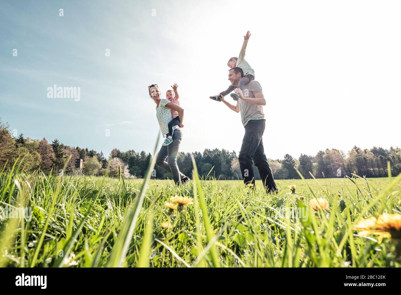 Happy family with two kids on a meadow in spring Stock Photo