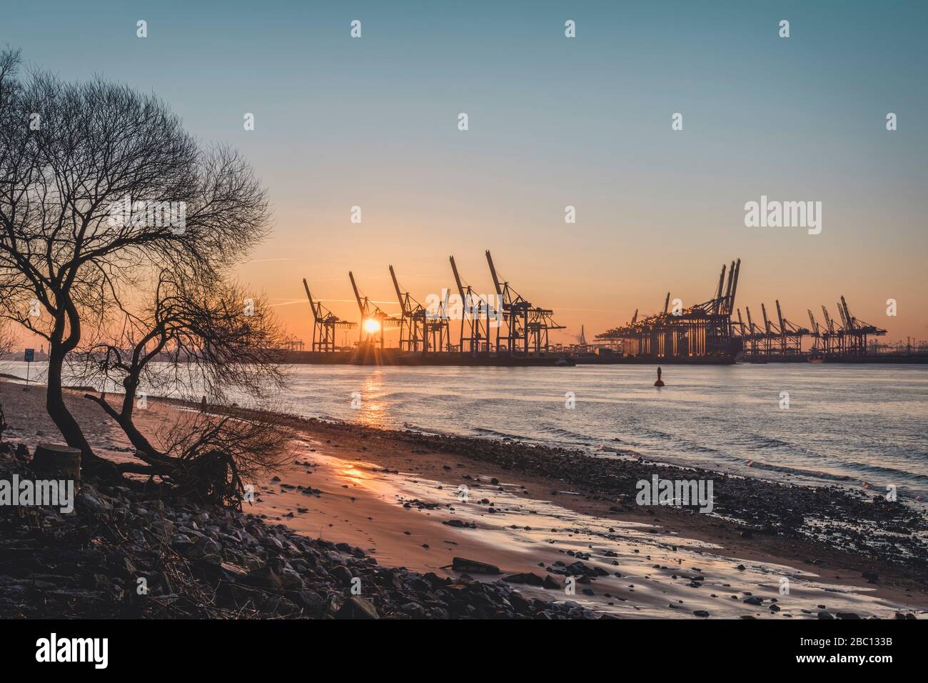 Elbe beach sunrise silhouettes harbor cranes background hi-res stock ...