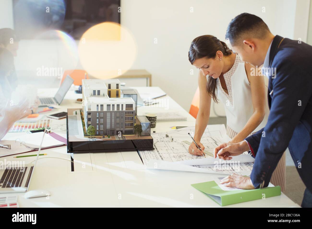 Architects drafting blueprint in conference room Stock Photo