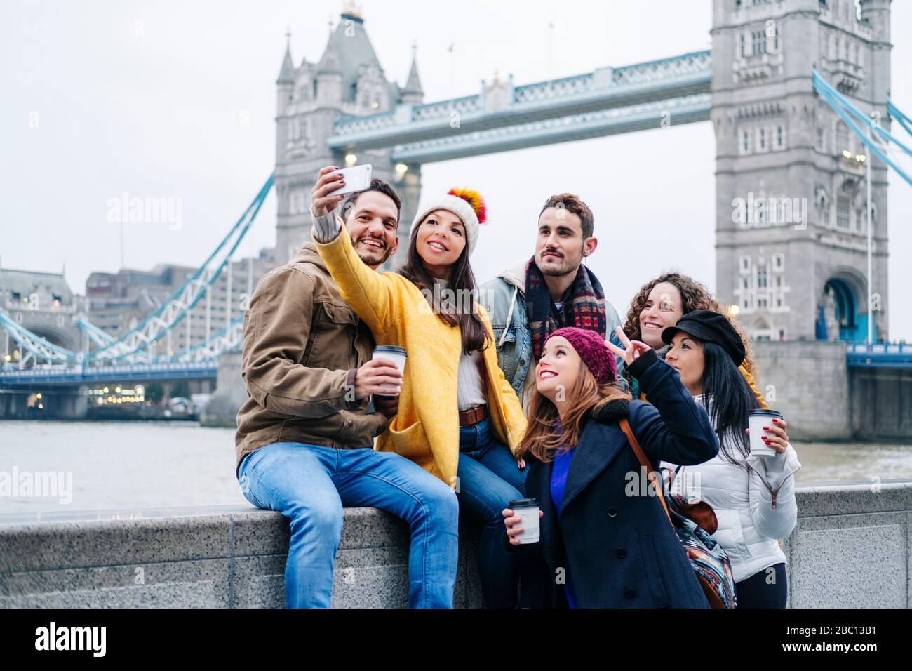 group-of-tourists-taking-smartphone-pictures-with-london-bridge-in-background-2BC13B1.jpg