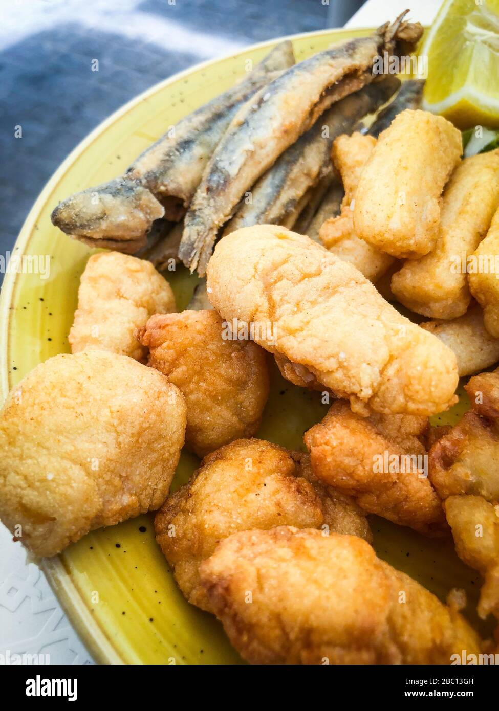 mix fried fishes & seafood plate with fresh lettuce & lemon juice Stock Photo Alamy
