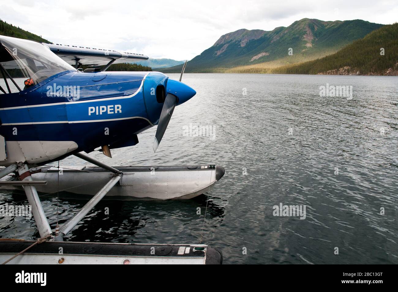 A single-engine, two-seater Piper Cub floatplane, on a lake in Spatsizi Plateau Wilderness Provincial Park in northern British Columbia, Canada. Stock Photo