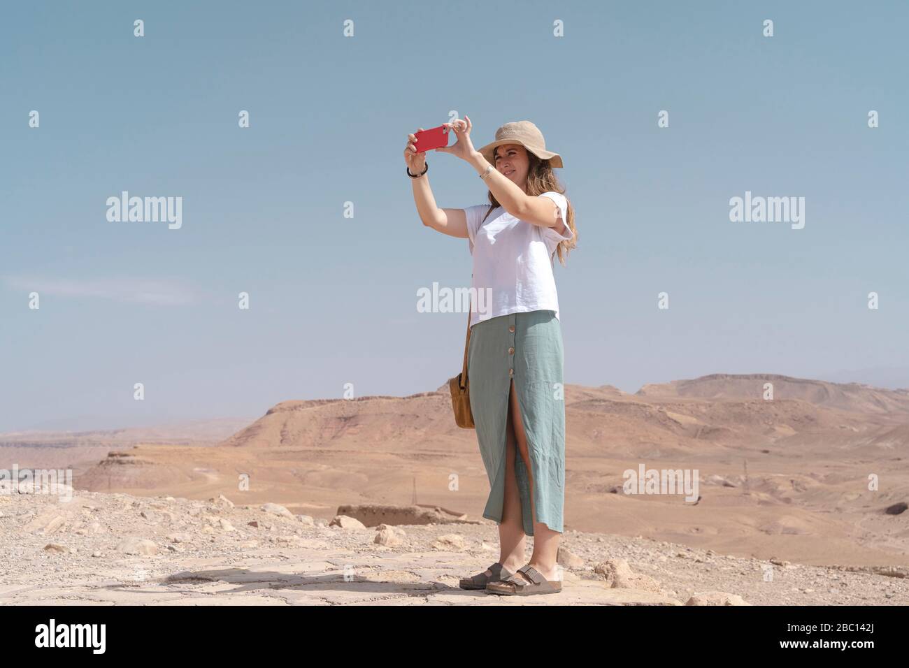 Young woman taking photos with smartphone, Ouarzazate, Morocco Stock Photo