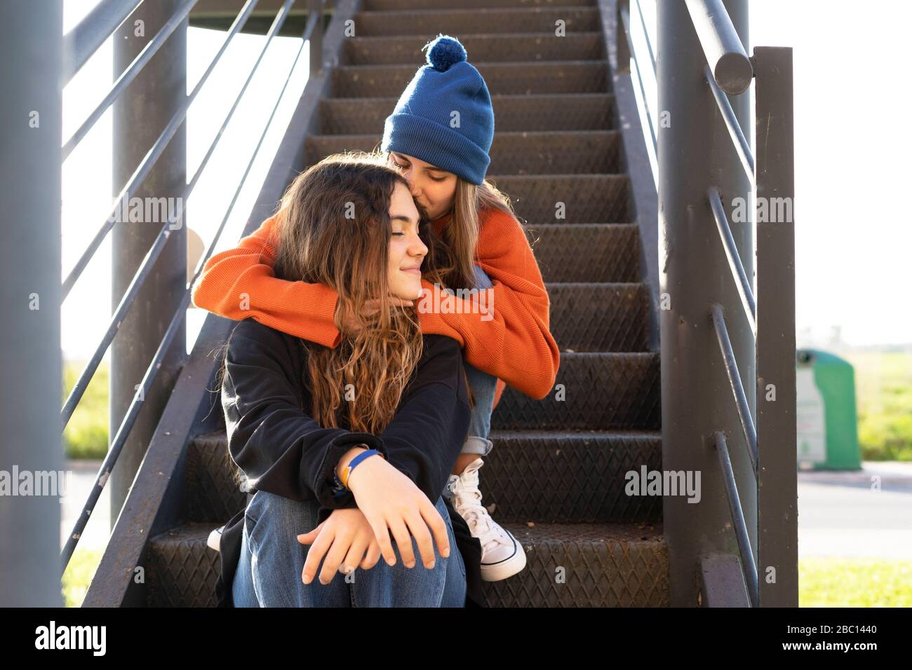 Two teenage girls sitting on stairs outdoors Stock Photo