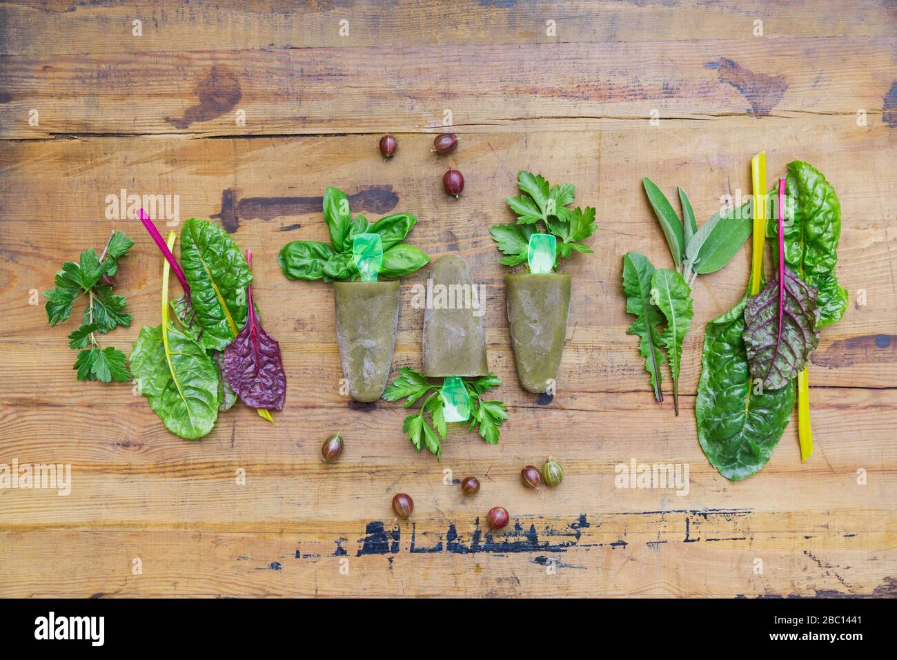 Overhead view of homemade green vegetables and herb popsicles on wooden table Stock Photo