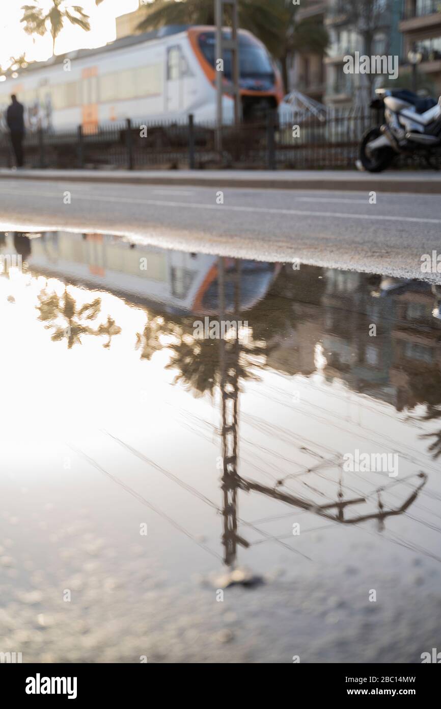 Spain, Barcelona, Badalona, Subway train reflecting in puddle of water Stock Photo