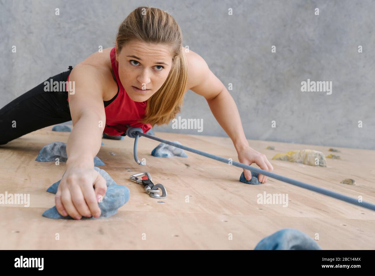 Woman climbing on the wall in climbing gym Stock Photo