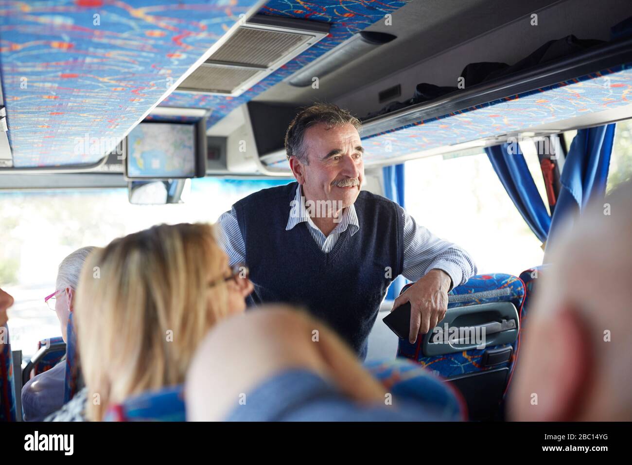 Smiling active senior man tourist on tour bus Stock Photo