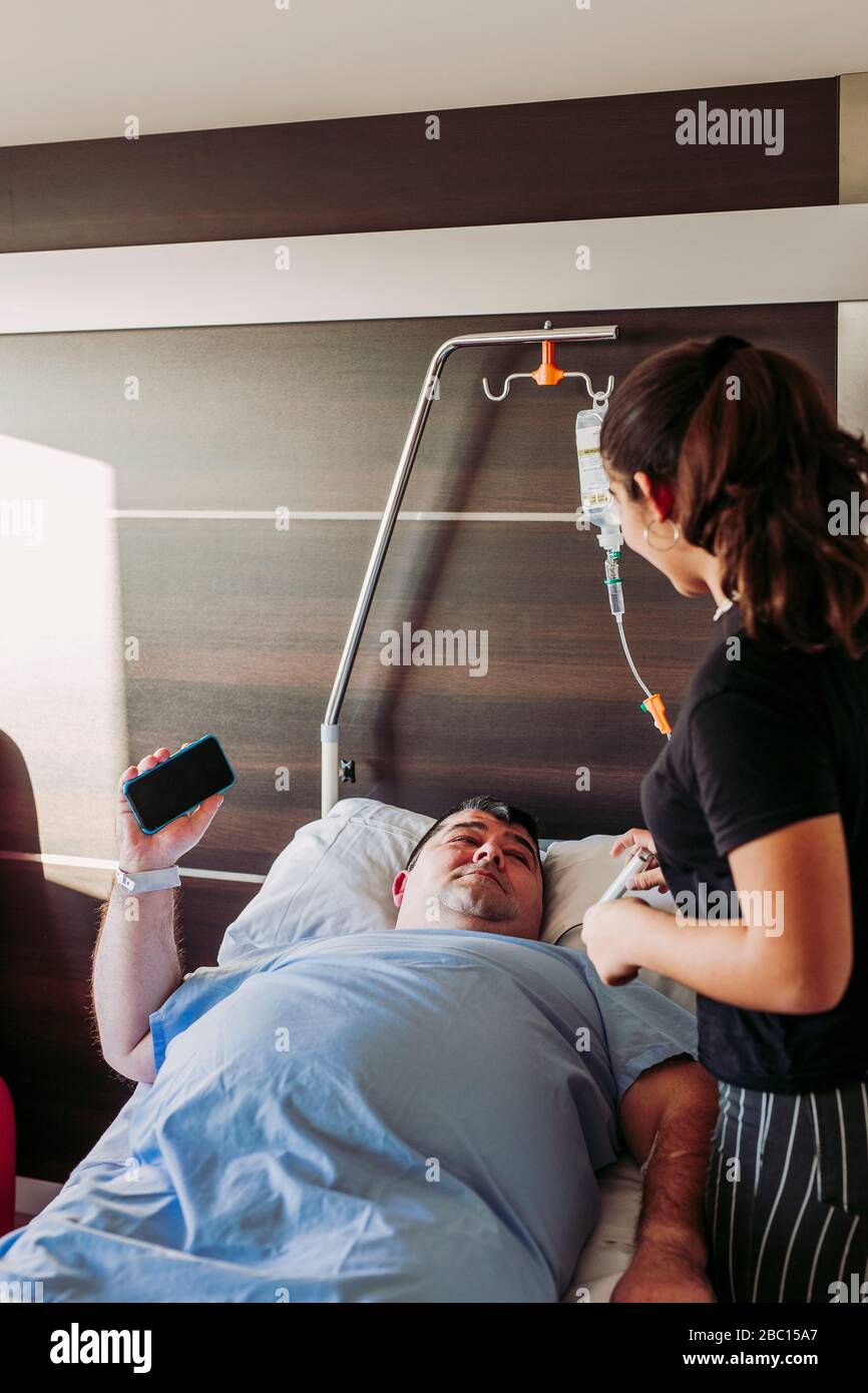 Daughter visiting father lying in hospital bed Stock Photo Alamy