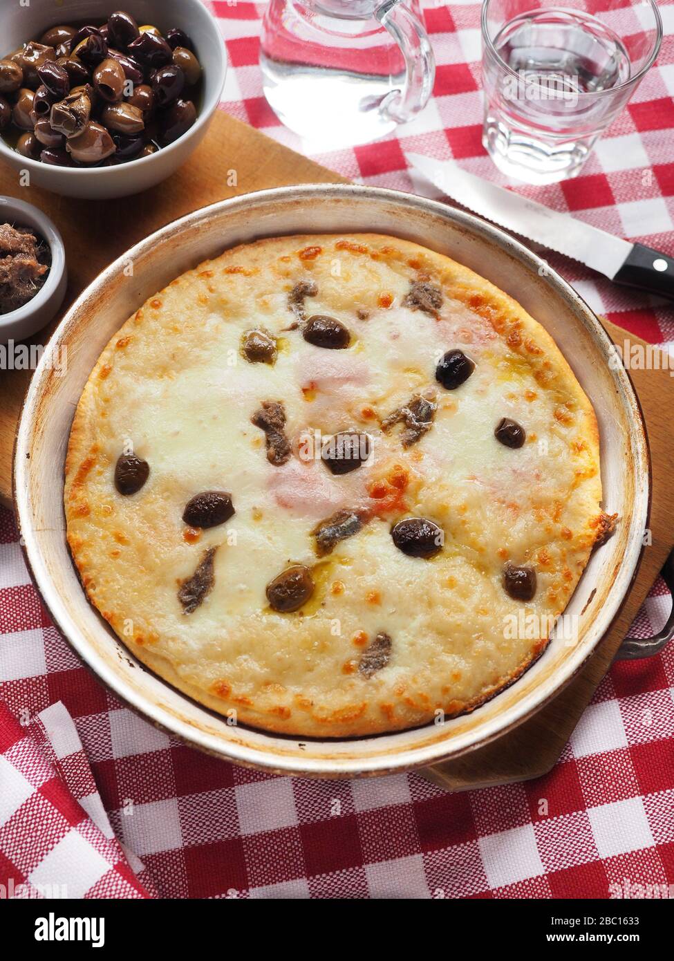 Pizza with mozzarella cheese, tomato, black olives taggiasche