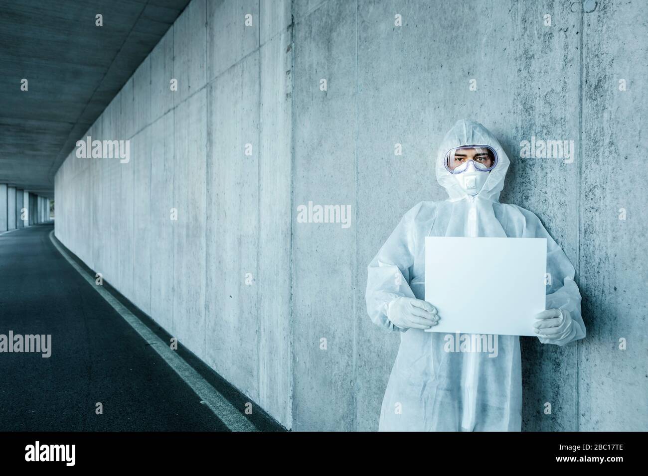 Portrait of man wearing protective clothing holding a blank sign Stock Photo