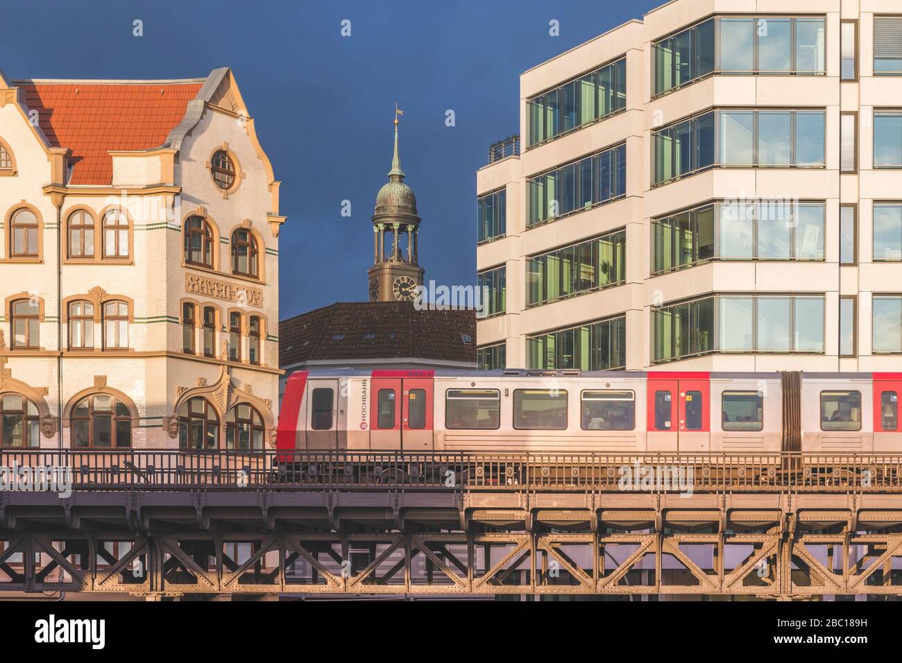 Germany, Hamburg, Elevated train with tower of Saint Michaels Church in background Stock Photo